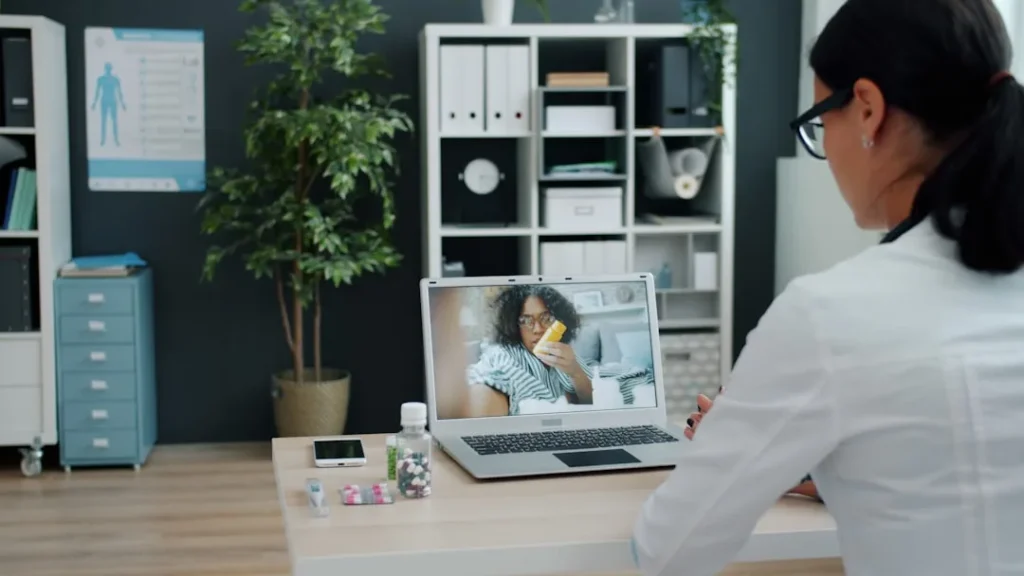 Doctor consulting patient via video call on laptop