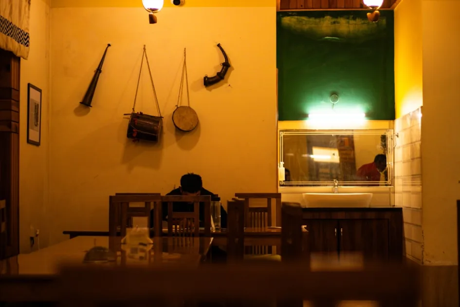 Person sitting at a table in a dimly lit room