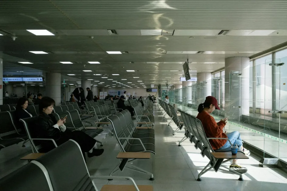 People waiting in a modern airport lounge by large windows