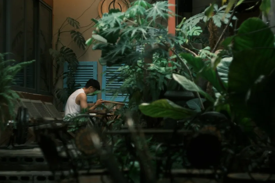 Man tending to plants on a balcony